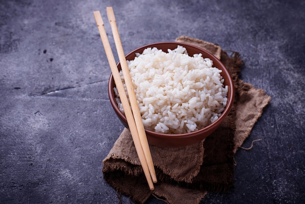 Bowl of boiled rice and chopsticks 