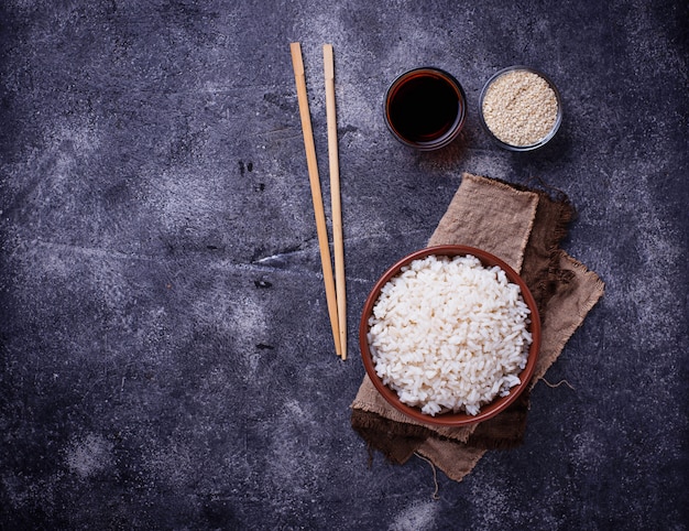 Photo bowl of boiled rice and chopsticks