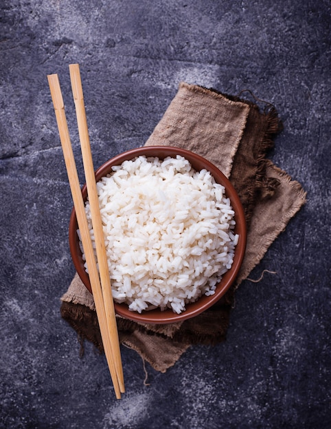 Bowl of boiled rice and chopsticks 