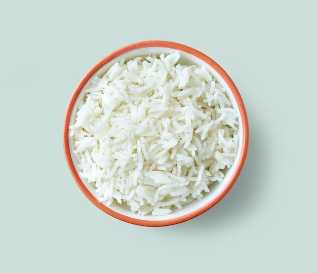 Bowl of boiled rice isolated on blue background, top view