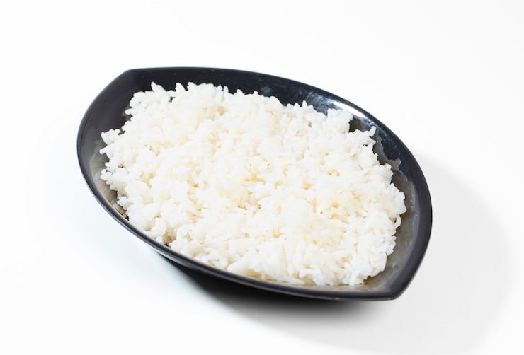 Photo bowl of boiled rice on white