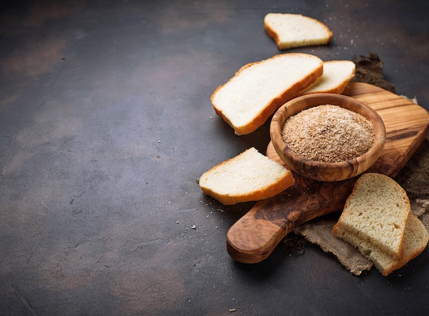 Bowl of breadcrumbs and slices of a loaf