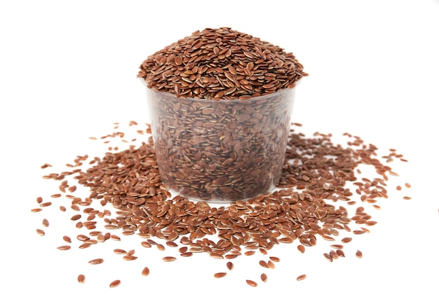 bowl of brown flax seeds and scattered isolated on white background