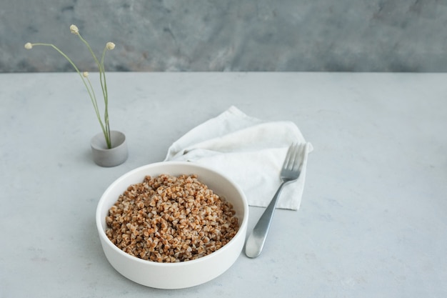 Ciotola di grano saraceno su uno sfondo di cemento grigio in stile minimalista superiore spazio sano copia copy