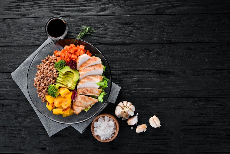 Фотография чаша будда гречневая тыква куриное филе авокадо морковь на черном фоне вид сверху свободное место для текста