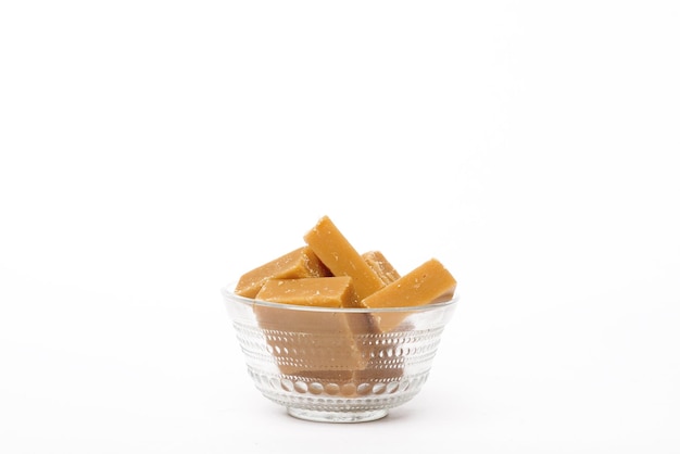 A bowl of caramel fudge on a white background.