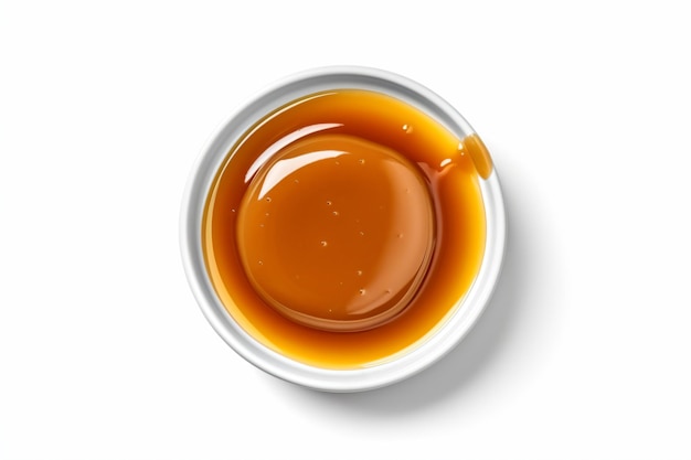 a bowl of caramel sauce on a white surface
