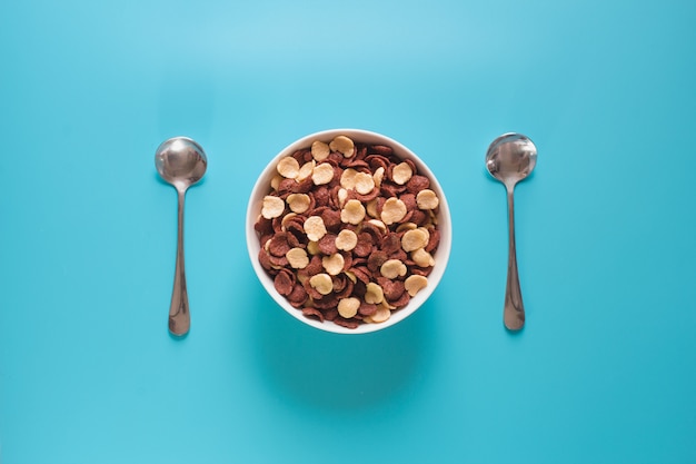 Photo bowl of cereal and spoon from top view