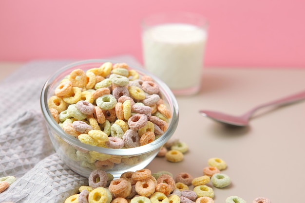 A bowl of cereal with a glass of milk in the background.