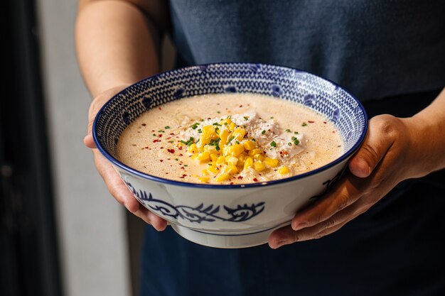 Bowl of cheese ramen noodle soup with corn