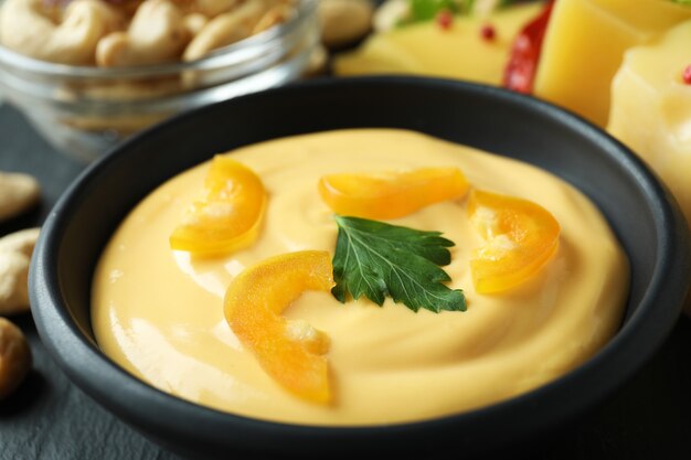 Bowl of cheese sauce and snacks, close up