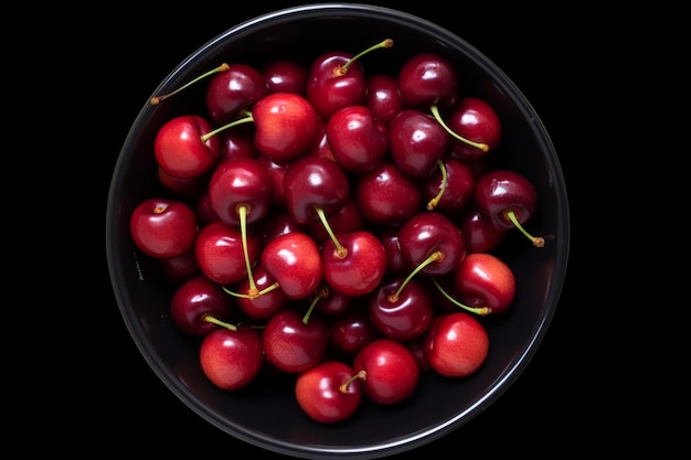 A bowl of cherries sits on a black background.