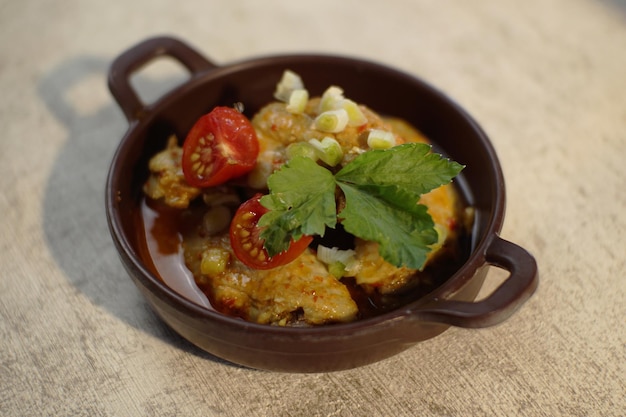 Foto una ciotola di pollo al curry con sopra un pomodoro a fette e il sedano