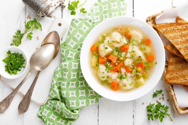 A bowl of chicken dumplings with a spoon next to it