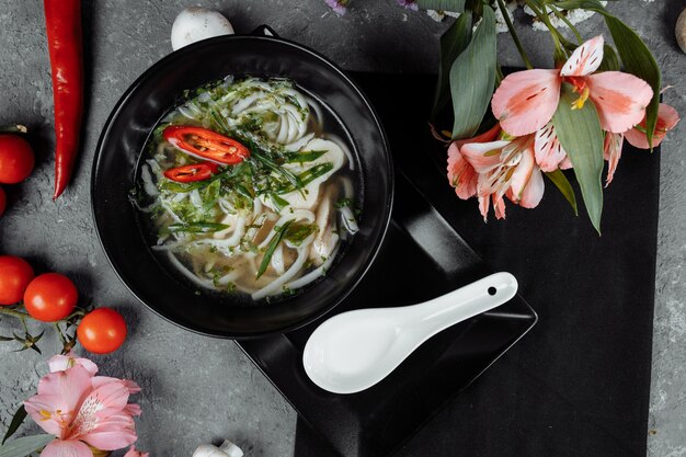 Bowl of chicken noodle on gray concrete