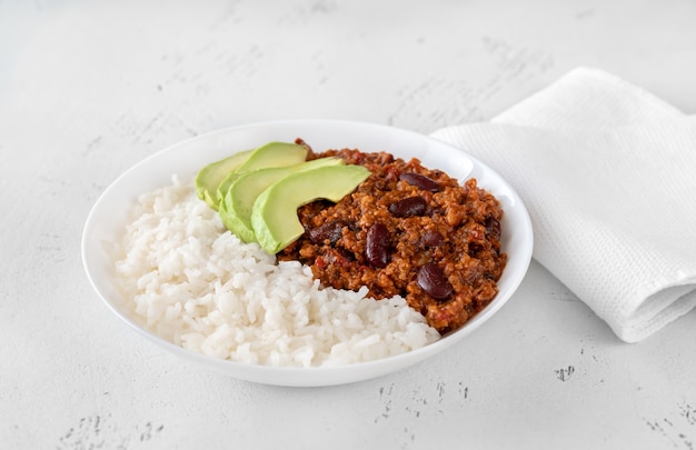 Bowl of chili con carne with rice, avocado and sour cream