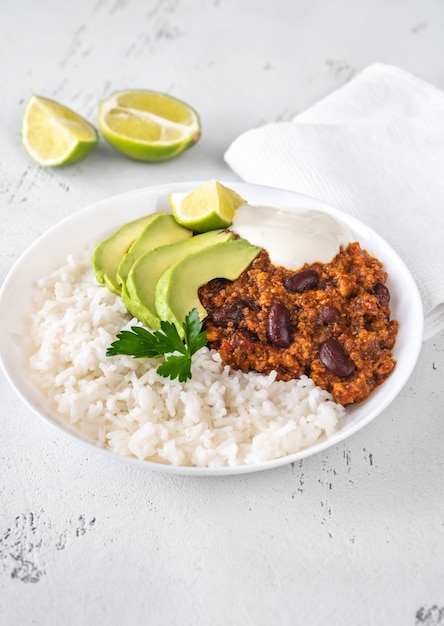 Bowl of chili con carne with rice, avocado and sour cream