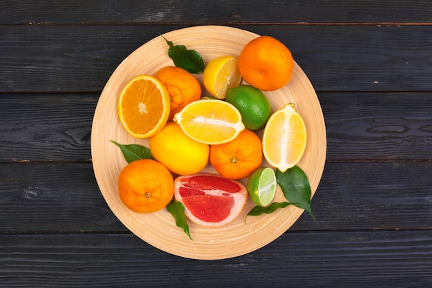 Bowl of citrus fruits on black wooden surface