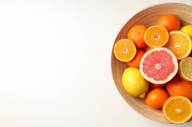 Bowl of citrus fruits on white background