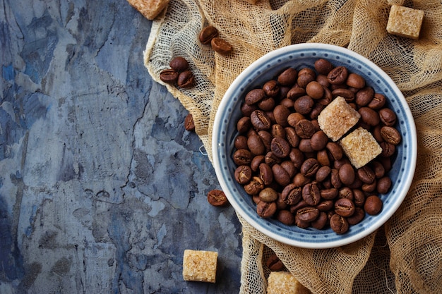 Bowl of coffee beans and brown cane sugar. Selective focus