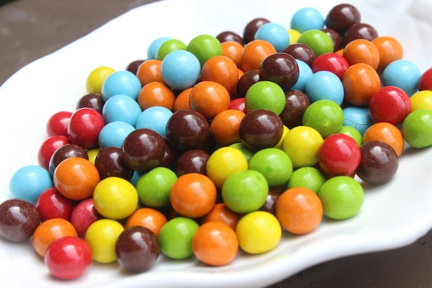 A bowl of colorful candy sits on a table.