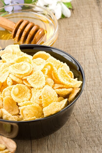 Bowl of corn flakes and nutrition on wooden surface