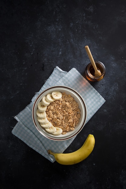 Bowl of corn flakes with banana an honey