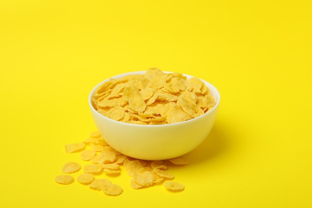 Bowl of corn flakes on yellow