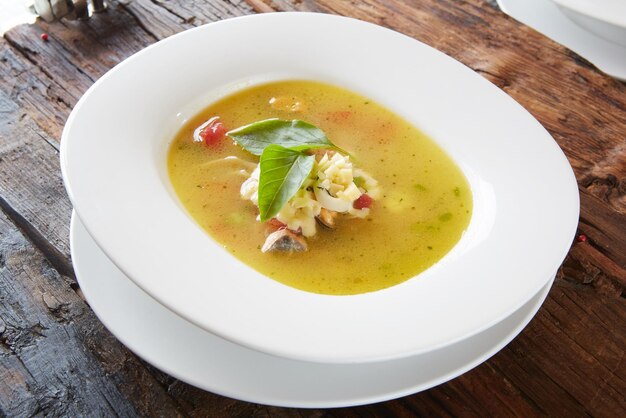 A bowl of crab soup with a leafy green leaf on top.