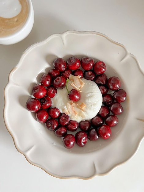 A bowl of cranberry cheese and a cup of coffee on a white table.