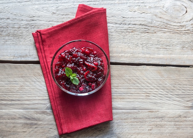 Foto ciotola di marmellata di mirtilli rossi su una tavola di legno