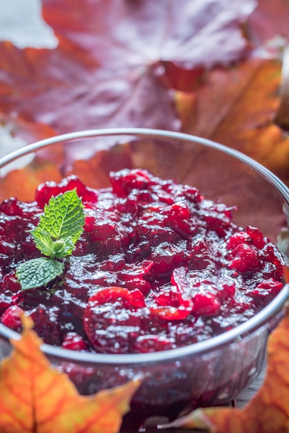 Bowl of cranberry sauce on the wooden board