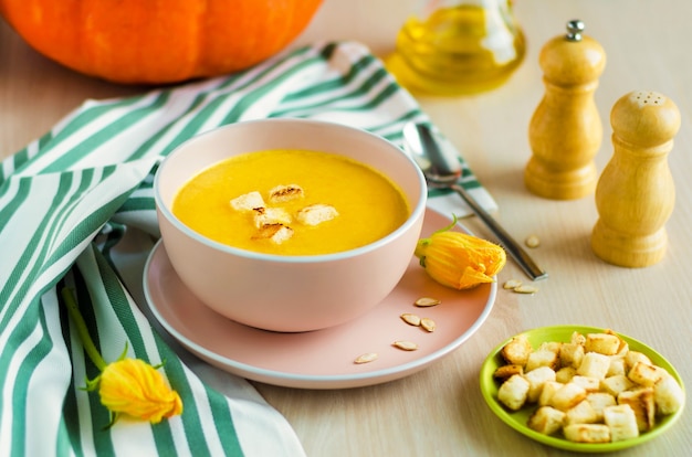 Bowl creamy pumpkin soup with vegetables, seeds and croutons, olive oil. Thanksgiving Day. traditional autumn dish.