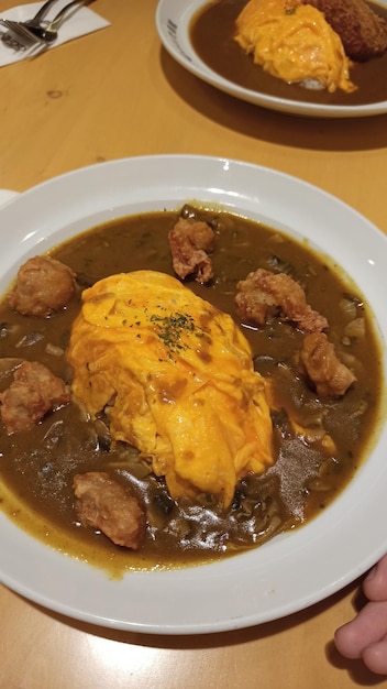 黄色い卵とフライドチキンが入ったカレーの鉢