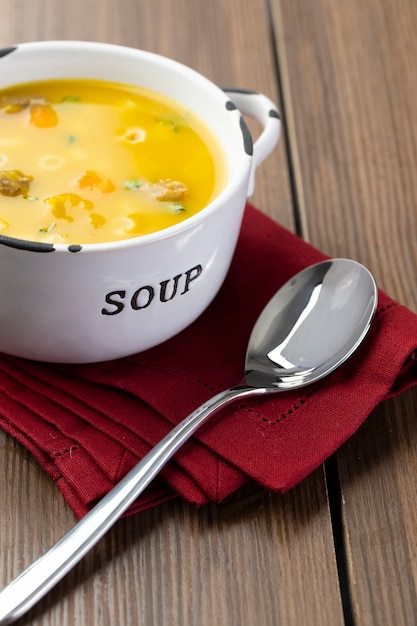 A bowl of delicious brazilian soup with beef, vegetables, noodles, carrots, and potato.