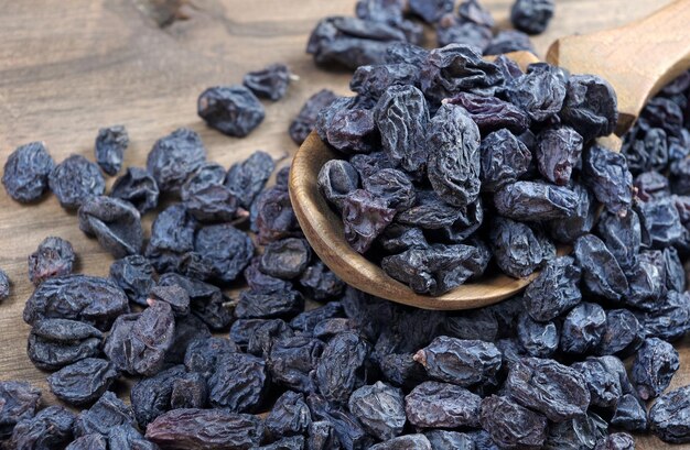 A bowl of dried blue raisins sits on a table.