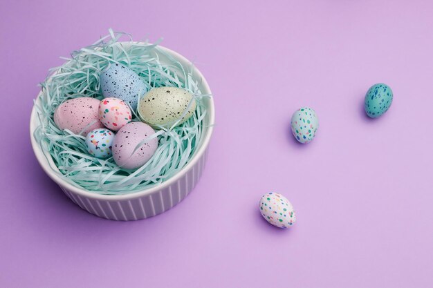 Photo a bowl of easter eggs on a purple background with a pink background.