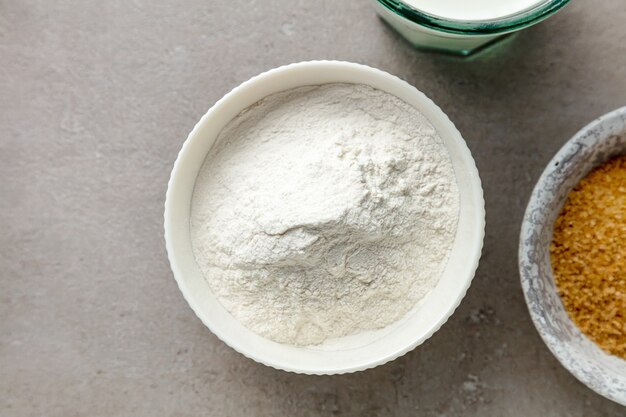 Bowl of flour on grey kitchen table, top view
