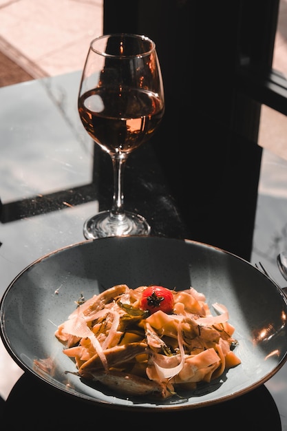 a bowl of food with a glass of wine next to it
