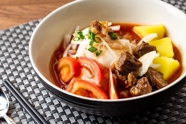 A bowl of food with meat and vegetables