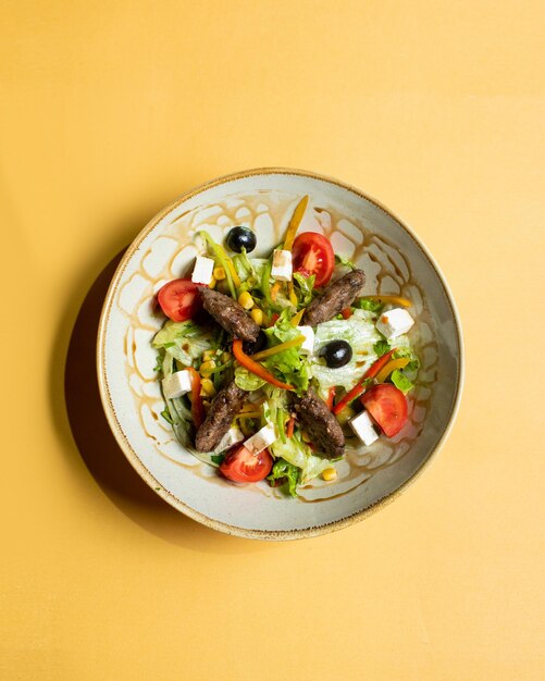 A bowl of food with a salad on it