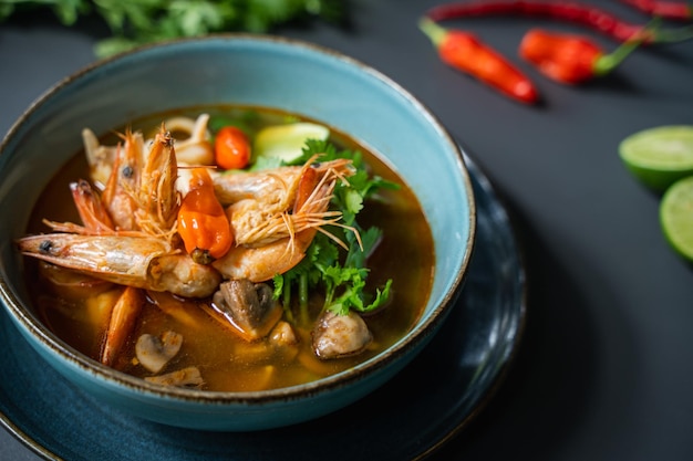 Photo a bowl of food with a spoonful of prawn and a red chili pepper on the side.