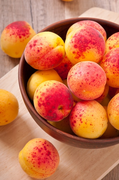 bowl of fresh apricots on wooden table