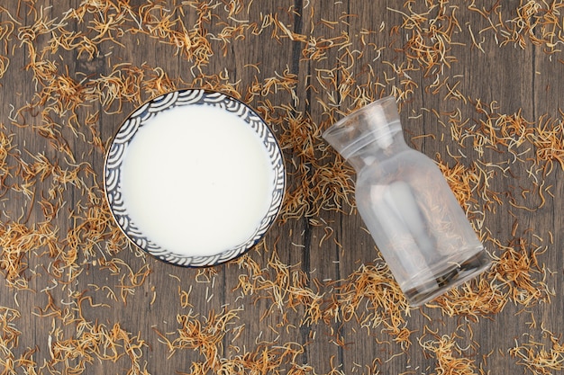 나무 테이블에 놓인 빈 유리 투수와 신선한 시원한 우유 한 그릇