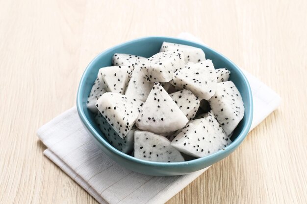 A bowl of fresh dragon fruit served on bowl on wooden background Breakfast fruit in the morning