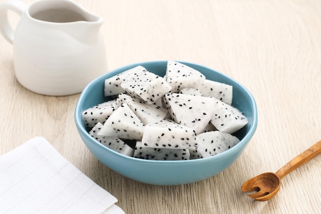 A bowl of fresh dragon fruit served on bowl on wooden background Breakfast fruit in the morning