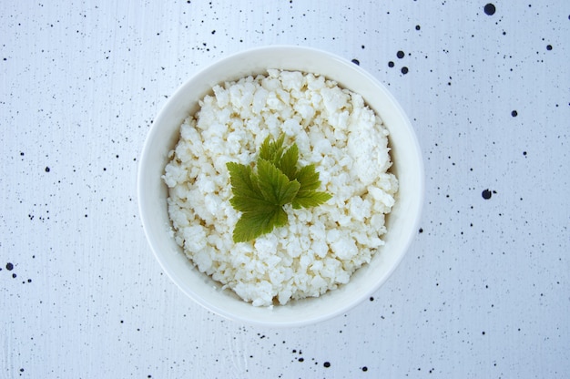 A bowl of fresh homemade cottage cheese on a white background