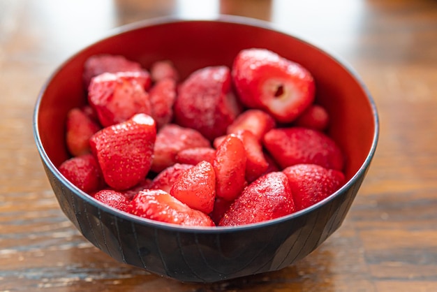 A bowl of fresh organic frozen strawberries used for smoothie