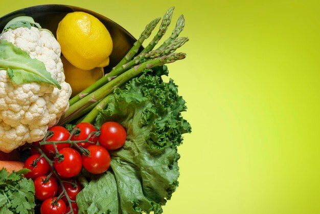 Bowl of fresh organic vegetables salad cauliflower tomato lemon asparagus