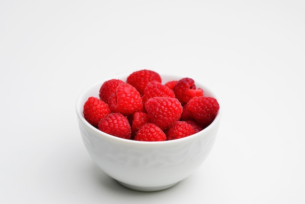 Bowl of fresh raspberries on white background Flat lay top view copy space Raspberries isolated on white background Raspberries Clipping Path Mint Raspberries macro studio photo